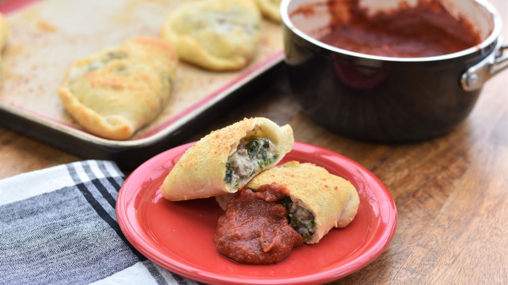 Calzone on a red plate with dipping sauce