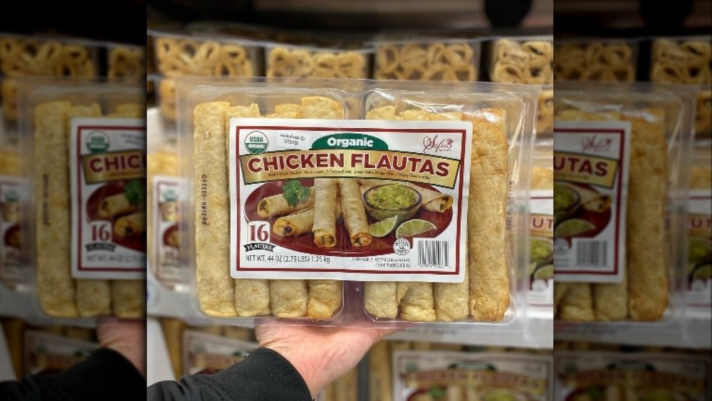 hand holding chicken flautas