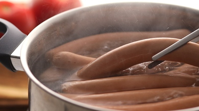 Hot dogs boiling in a pot.