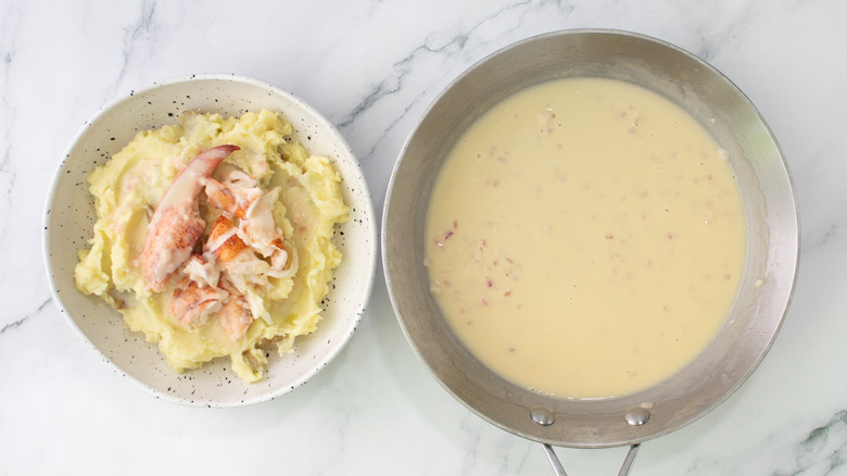 lobster and mashed potatoes in a bowl next to cookware with beurre bier blanc sauce