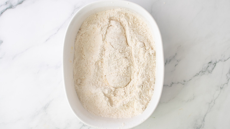 fully coated chicken tender in flour mixture