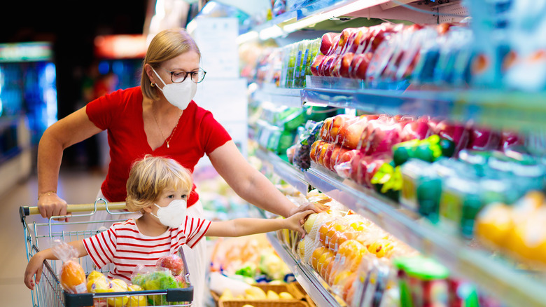 Family in masks shopping at grocery store