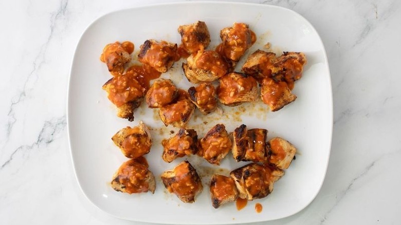 Chicken on plate coated in Buffalo sauce