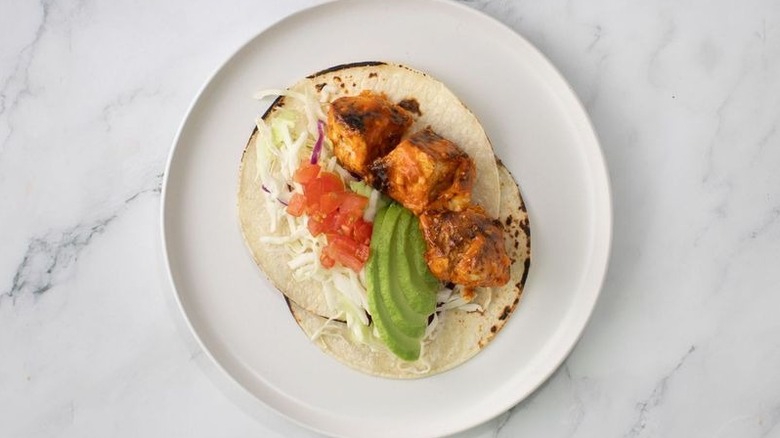 Buffalo chicken taco with avocado and tomatoes