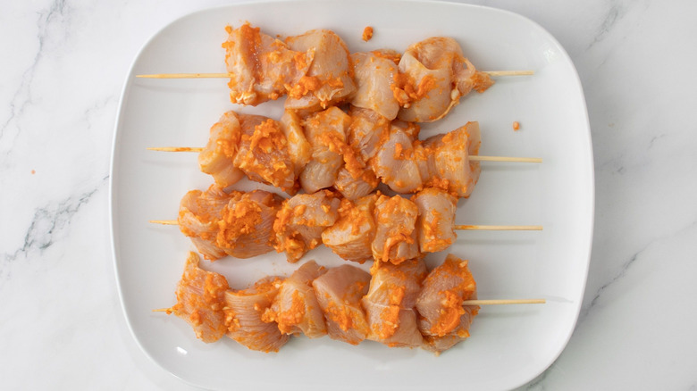 Buffalo chicken pieces on skewers