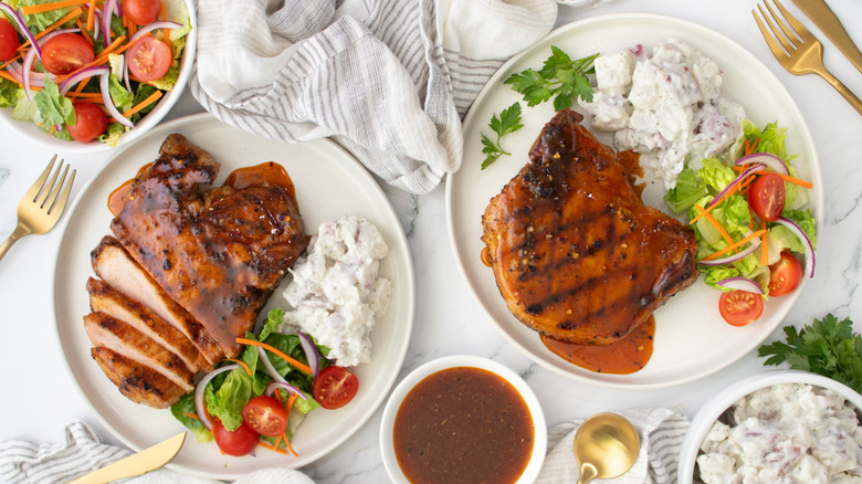 two plates with grilled pork chops with honey bbq sauce