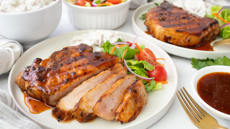 sliced pork chop with bbq sauce and salad