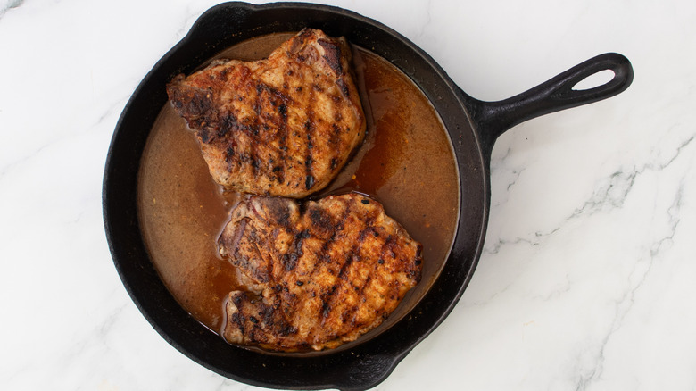grilled pork chops in skillet with honey butter bbq sauce