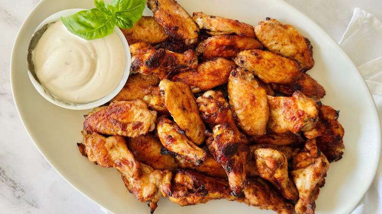 Dry rub chicken wings on serving platter with bowl of ranch