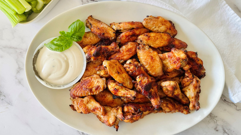 Wingstop hot honey rubbed wings on plate with bowl of ranch