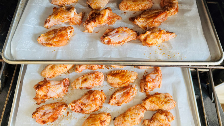 Chicken wings on baking sheets in oven
