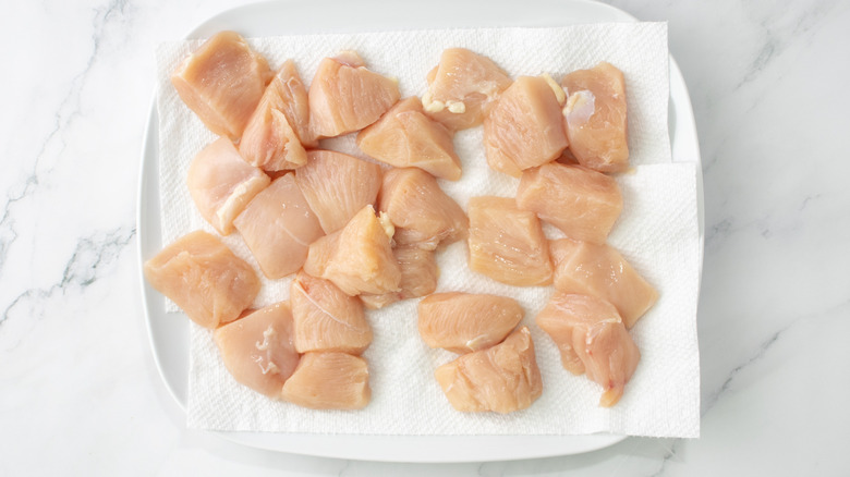 raw chicken chunks on a paper towel