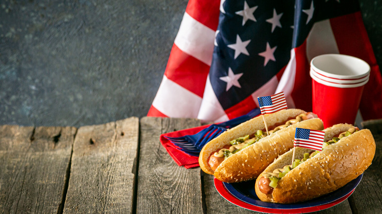 Two hot dogs with paper cups and an American flag