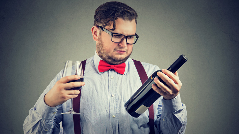 Man giving dubious look to bottle