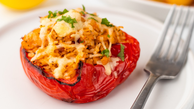 Cheesy stuffed bell pepper on plate with fork