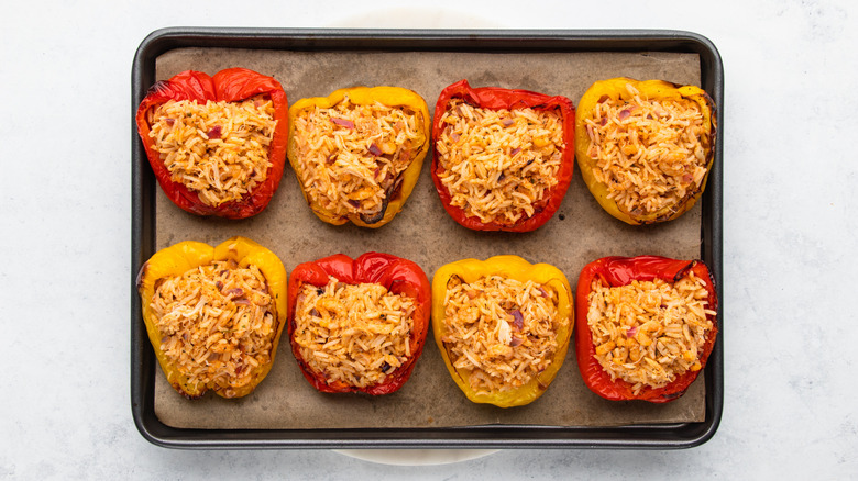 Stuffed bell peppers on parchment-lined baking sheet