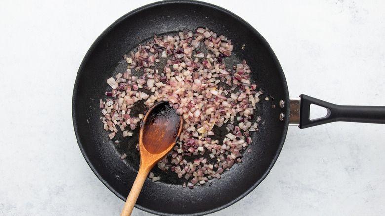 Diced red onion sauteing in frying pan