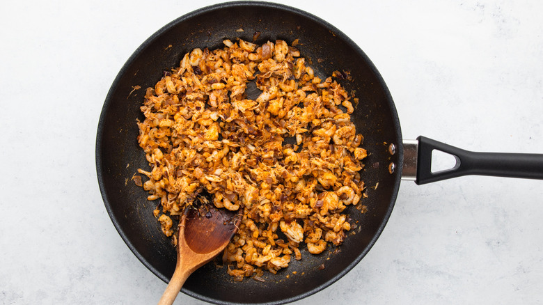 Seasoned crab meat and shrimp cooking in frying pan
