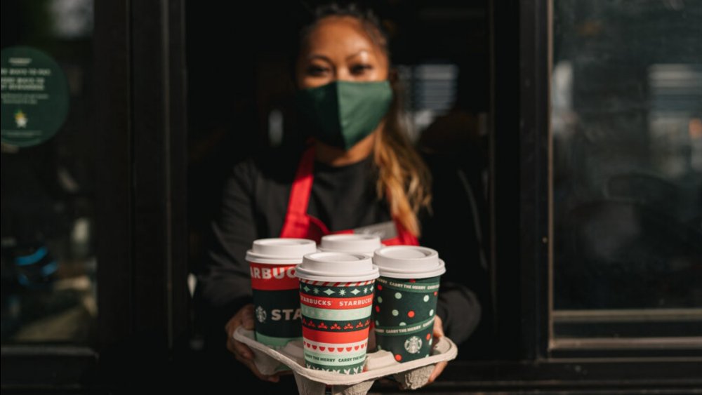 Barista handing over holiday drinks