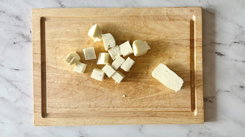 Cubed halloumi cheese on wooden board