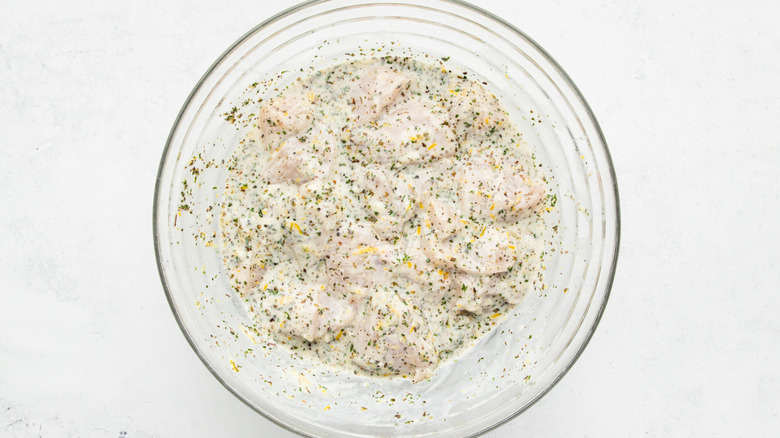 Bowl of diced chicken in lemon-herb marinade
