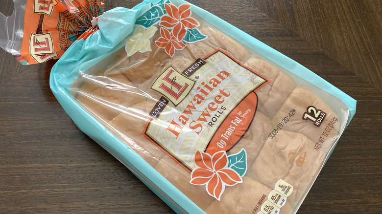 A package of L'Oven Fresh Hawaiian sweet rolls sits on a wooden background.