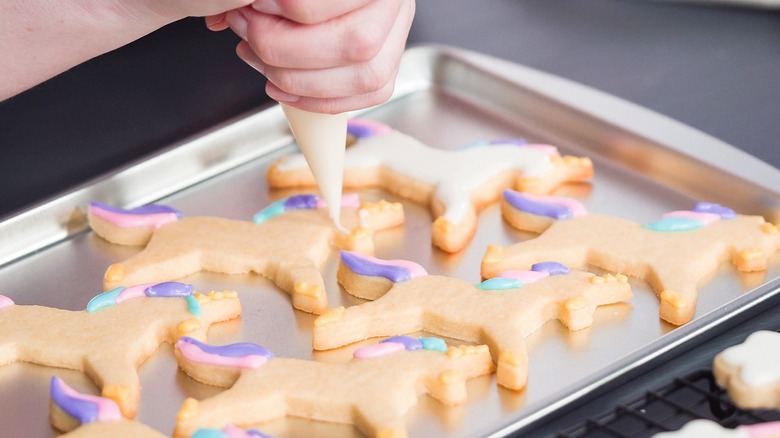 piping icing onto sugar cookies