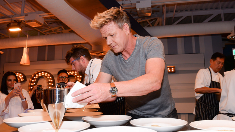 Gordon Ramsay carefully prepares plates at a cooking demonstration