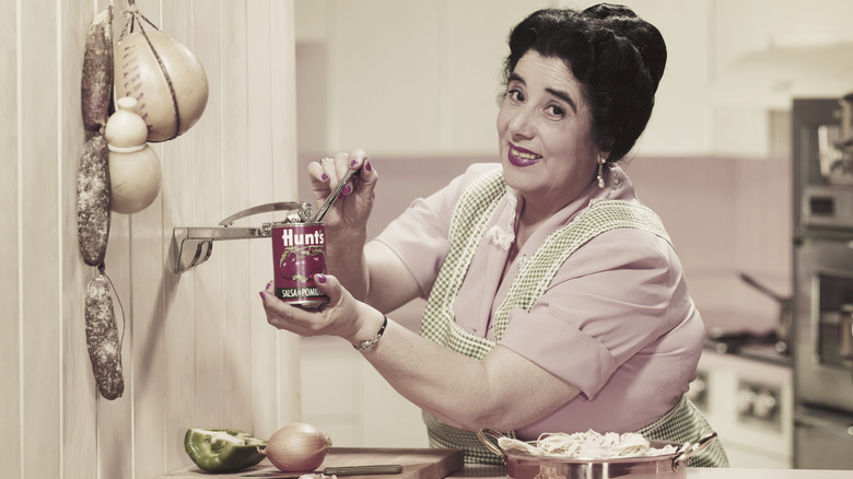 Older woman making spaghetti and using a can opener