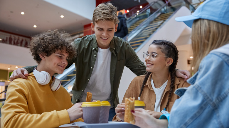 Teenagers eating in mall food court