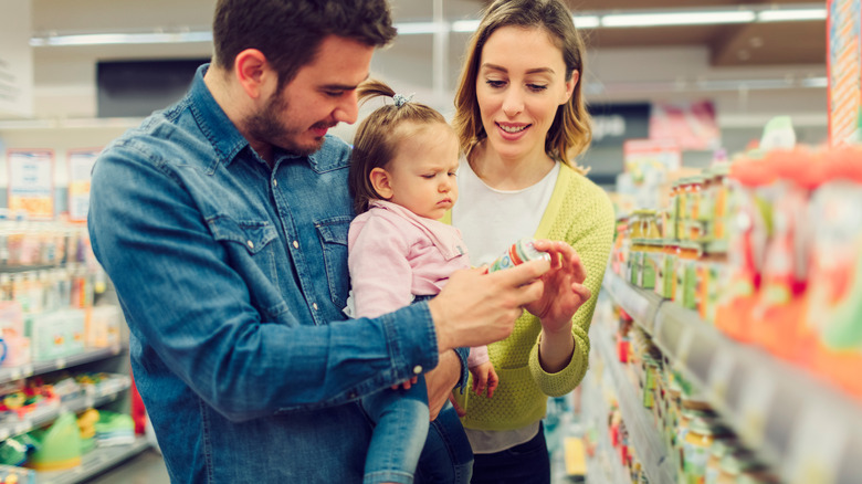 parents and baby looking at baby food jar