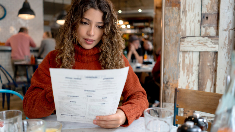 Restaurant patron reading menu