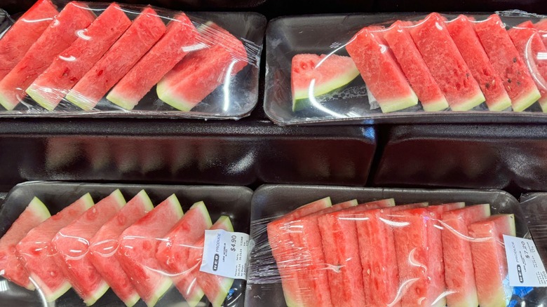 Sliced watermelon wrapped in plastic on sale at grocery store