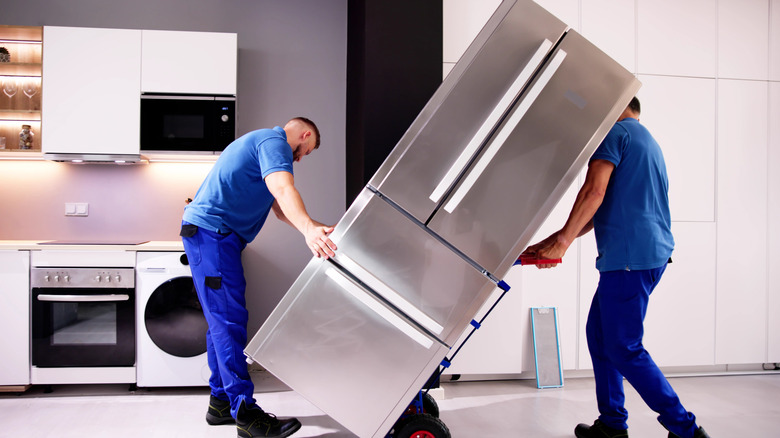 Delivery people moving refrigerator