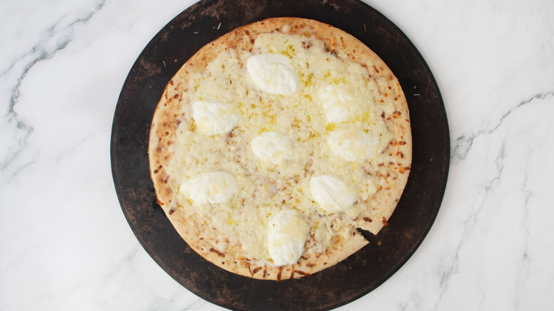 Cheesy pizza with dollops of ricotta