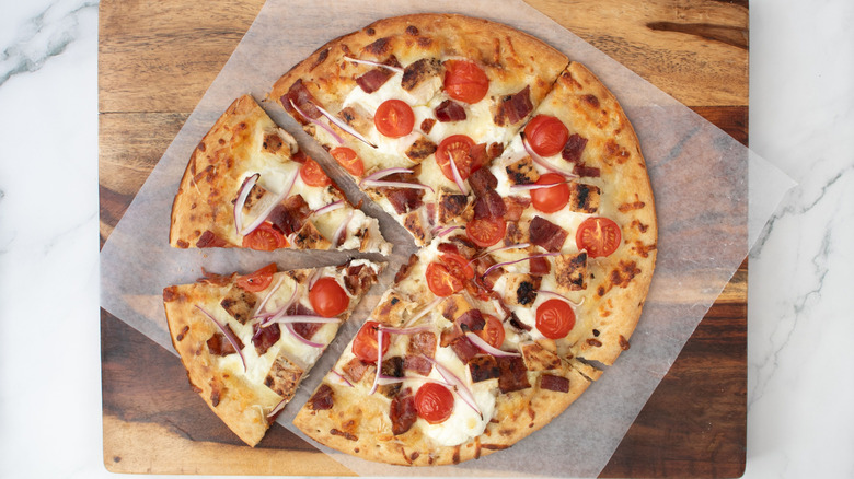 Sliced chicken bacon ranch pizza on parchment paper