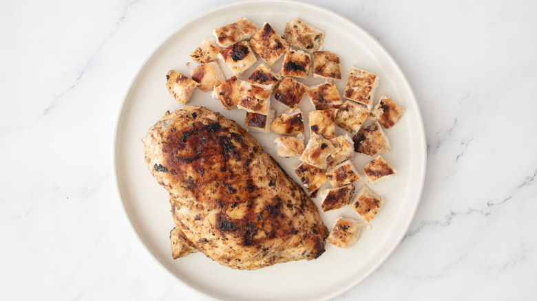 Whole chicken breast and diced chicken on white plate