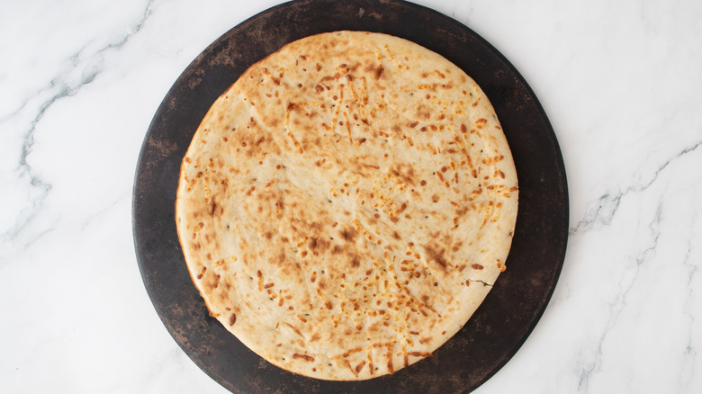 Pizza crust on round baking stone