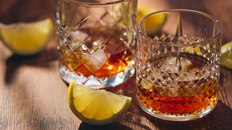 Bourbon in a glass with a lemon wedge on the side