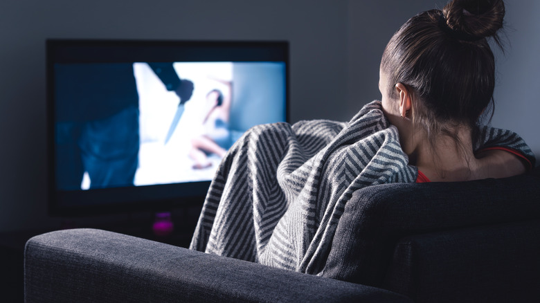 Woman watching horror film on TV