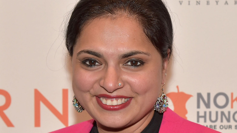 Maneet Chauhan smiling in pink jacket and earrings
