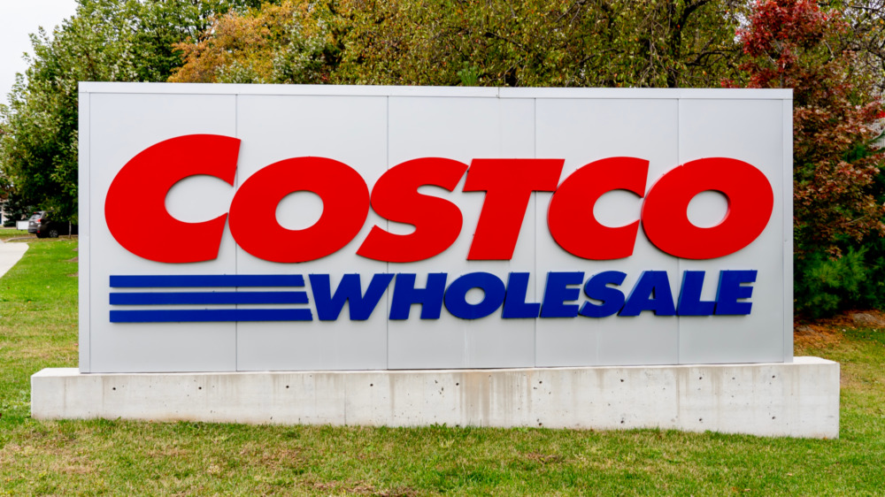 A Costco sign and greenery