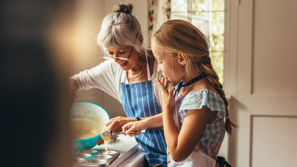 Grandma and granddaughter making cupcakes