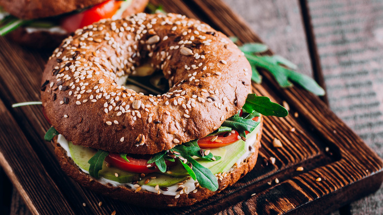 A real avocado bagel with tomatoes, arugula, avocado and cream cheese