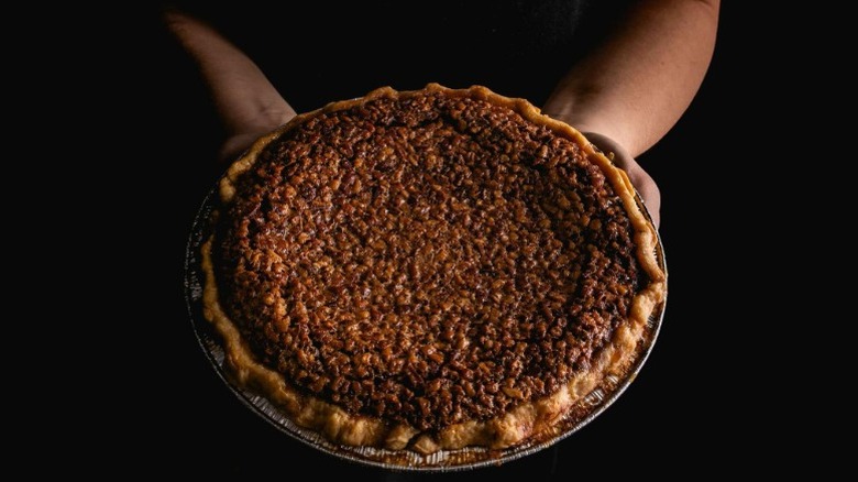 Person holding chocolate pecan bourbon pie