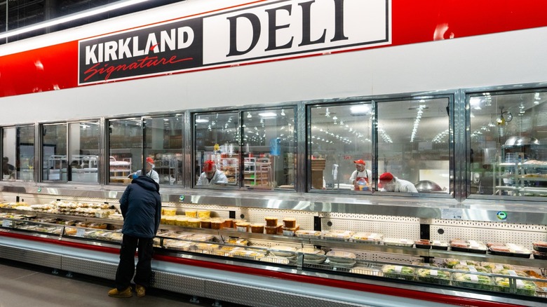 Costco's Kirkland Signature deli, showing a shopper looking at prepared foods