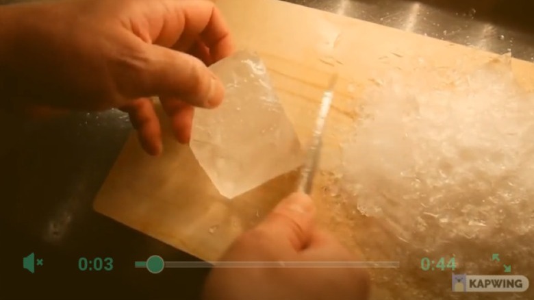 Bartender cutting large block of ice
