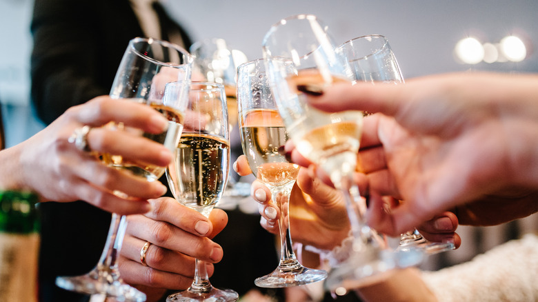 People celebrating with multiple flutes 