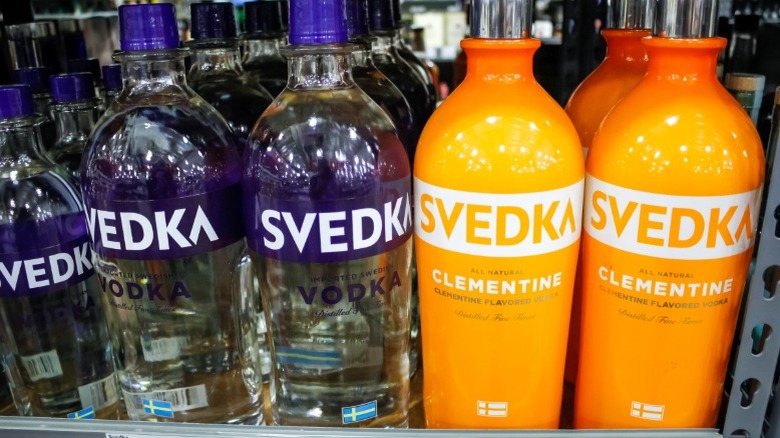 Bottles of original and clementine-flavored Svedka vodka on store shelf.
