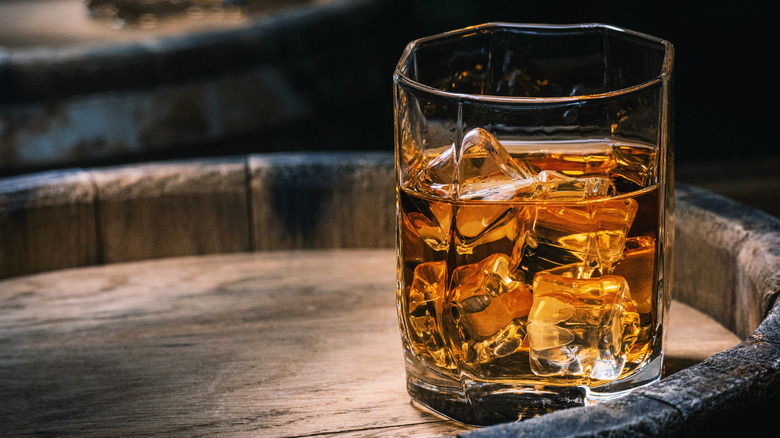 glass of bourbon with ice on tray